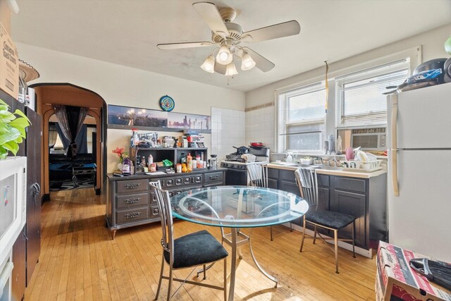 dining area with light wood-type flooring, cooling unit, and a ceiling fan