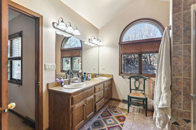 full bath featuring double vanity, visible vents, lofted ceiling, and a sink