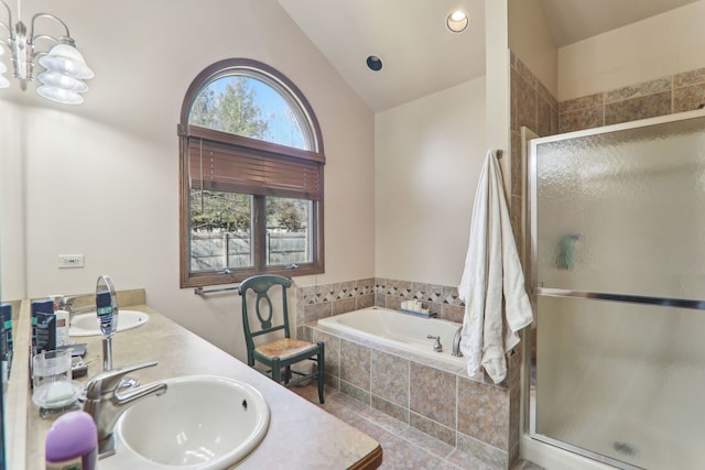 bathroom with lofted ceiling, a garden tub, a stall shower, and a sink