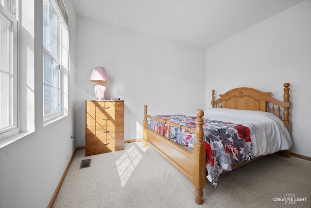 carpeted bedroom featuring visible vents and baseboards