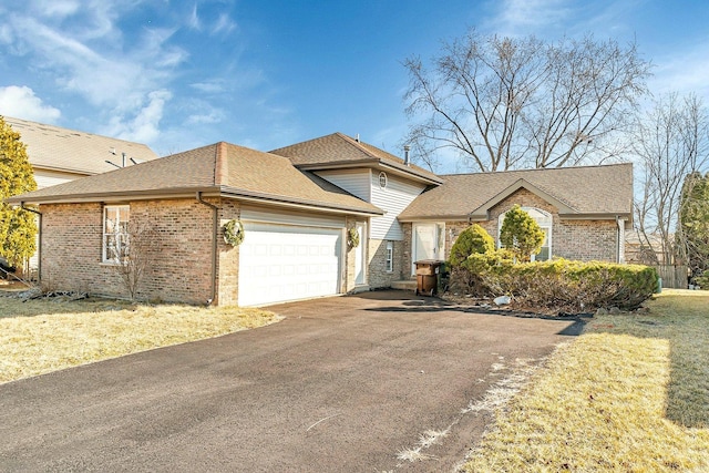 view of front of property featuring aphalt driveway, a garage, brick siding, and roof with shingles