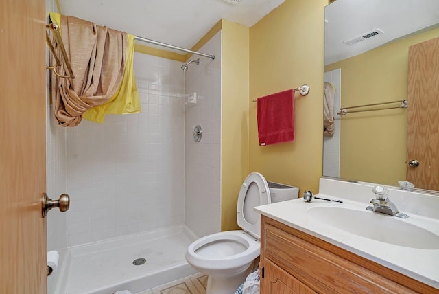 full bathroom featuring vanity, toilet, visible vents, and a stall shower