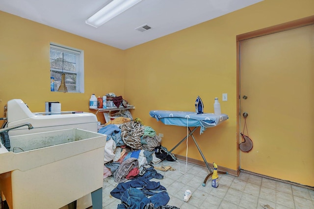 laundry area featuring visible vents, a sink, baseboards, washer / dryer, and laundry area