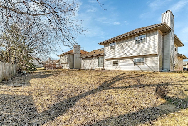 back of property featuring fence and a chimney