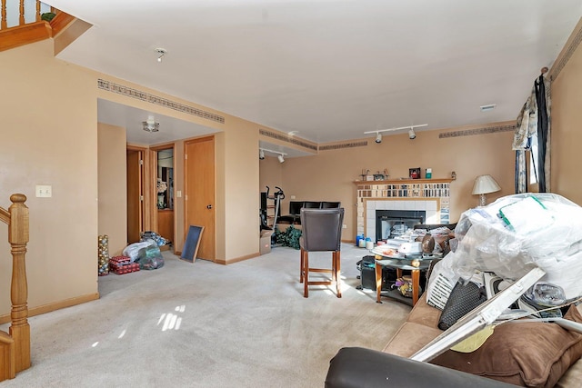 living room featuring baseboards, track lighting, a fireplace, and carpet flooring