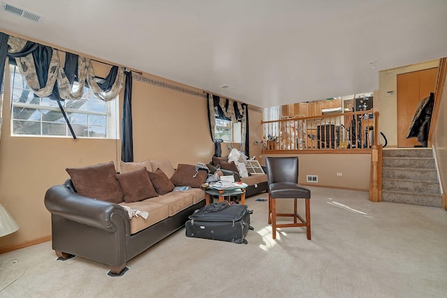 carpeted living room featuring visible vents, stairway, and baseboards