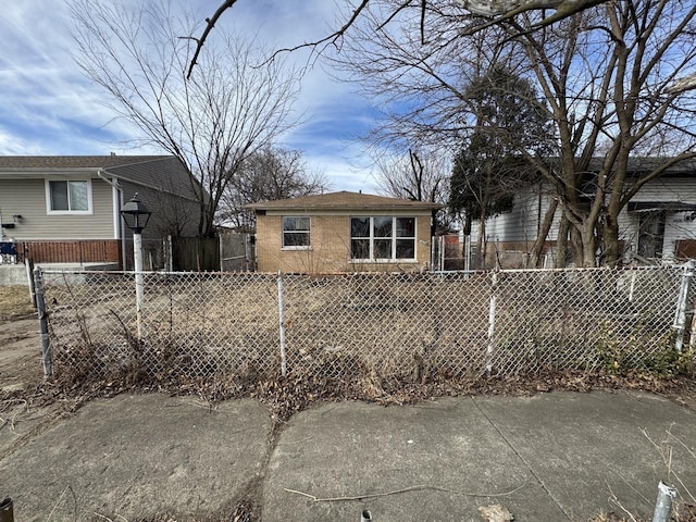 back of property featuring a fenced front yard and brick siding