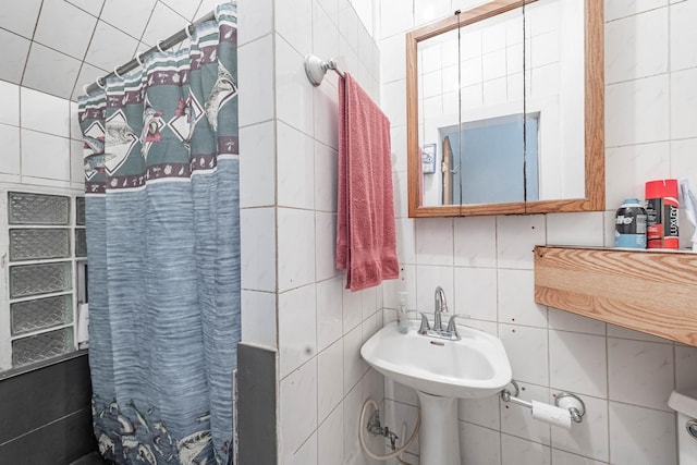 full bath with curtained shower and tile walls