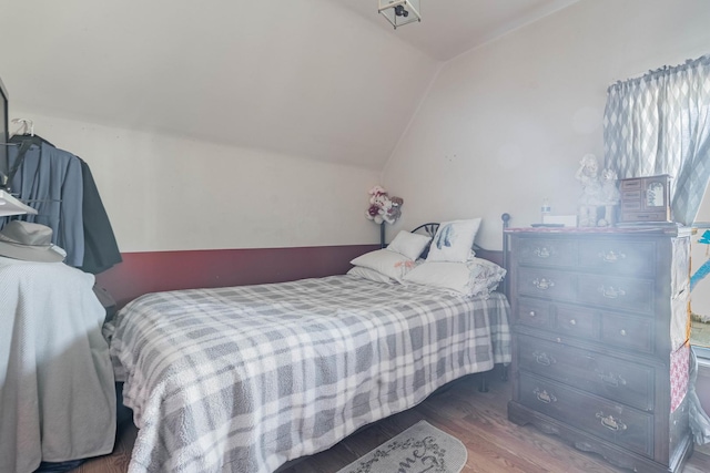 bedroom featuring wood finished floors and vaulted ceiling