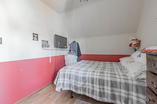 bedroom featuring vaulted ceiling and wood finished floors