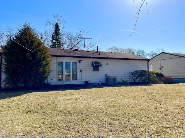 back of property with central AC and a yard