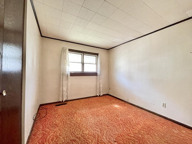 carpeted spare room with crown molding and baseboards