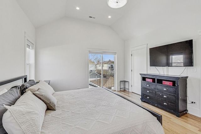 bedroom with visible vents, light wood-style flooring, vaulted ceiling, and access to outside