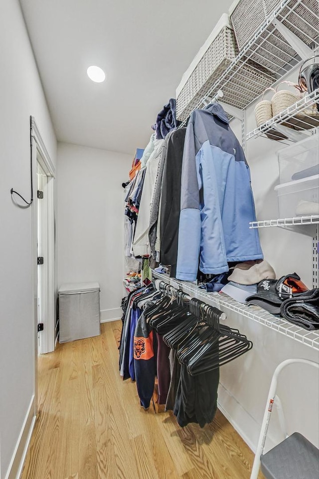 walk in closet with wood finished floors