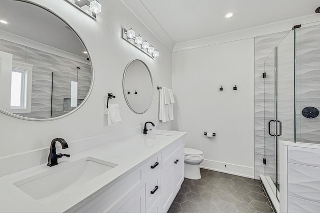 full bathroom featuring a sink, toilet, a stall shower, and double vanity