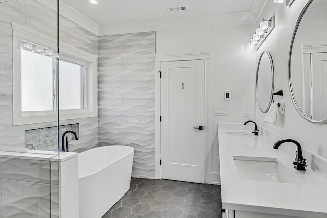 full bathroom featuring a sink, visible vents, a soaking tub, and tile walls