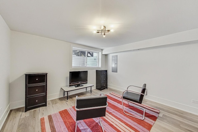 living room with electric panel, light wood-type flooring, and baseboards