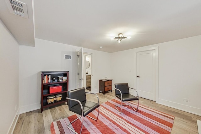 office featuring baseboards, visible vents, and light wood finished floors