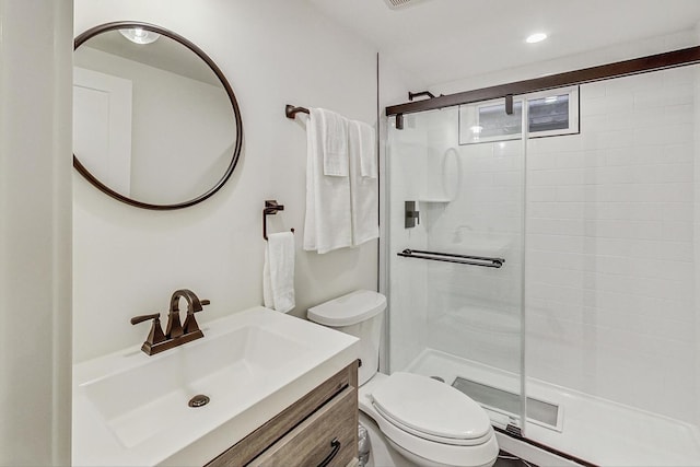 bathroom with recessed lighting, toilet, a stall shower, and vanity