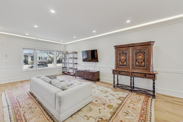 living area featuring recessed lighting, wood finished floors, and a wainscoted wall