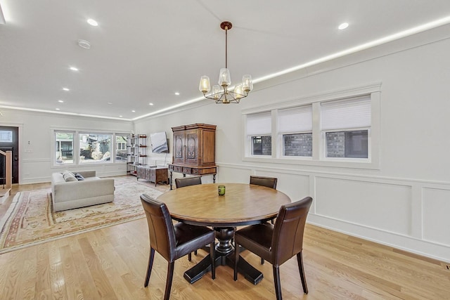 dining room featuring a decorative wall, a wainscoted wall, recessed lighting, light wood-style floors, and a notable chandelier