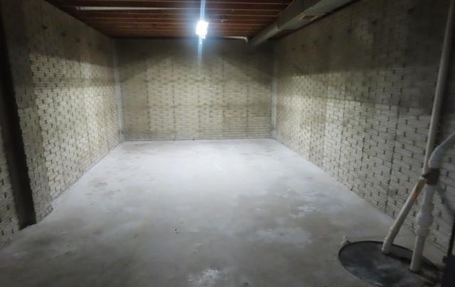 unfinished basement featuring brick wall