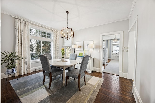 dining room with baseboards, crown molding, an inviting chandelier, and wood finished floors