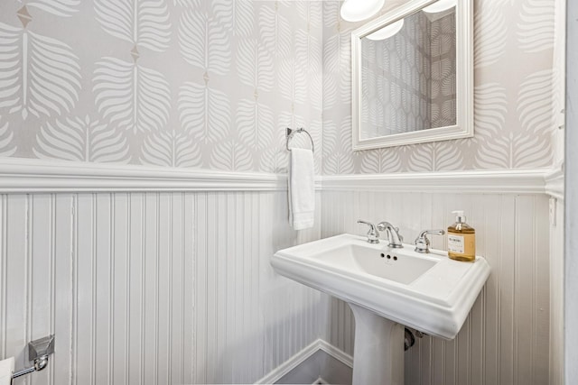 bathroom with a sink and a wainscoted wall