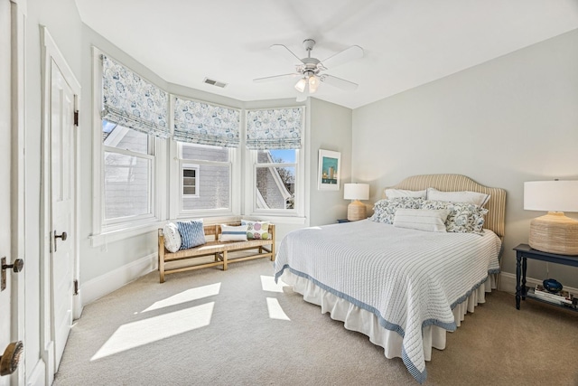 carpeted bedroom featuring visible vents, baseboards, and ceiling fan