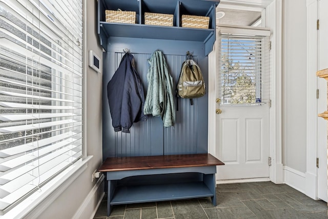 mudroom with stone finish floor and baseboards