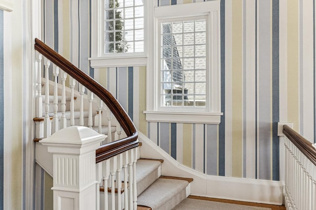 staircase featuring a healthy amount of sunlight and wallpapered walls