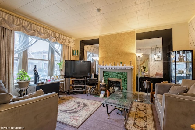 living room featuring ornamental molding, a fireplace, and wallpapered walls