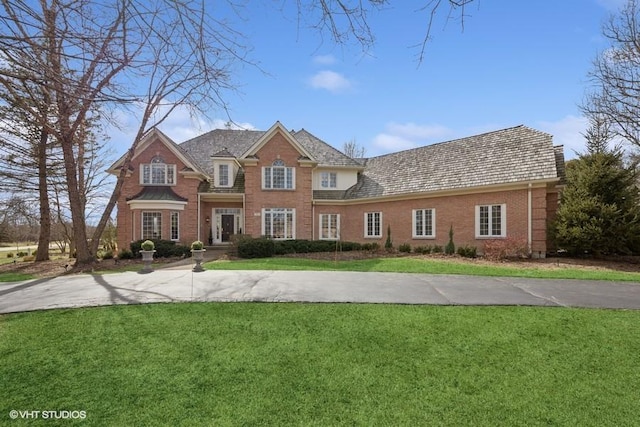 view of front facade featuring brick siding and a front lawn