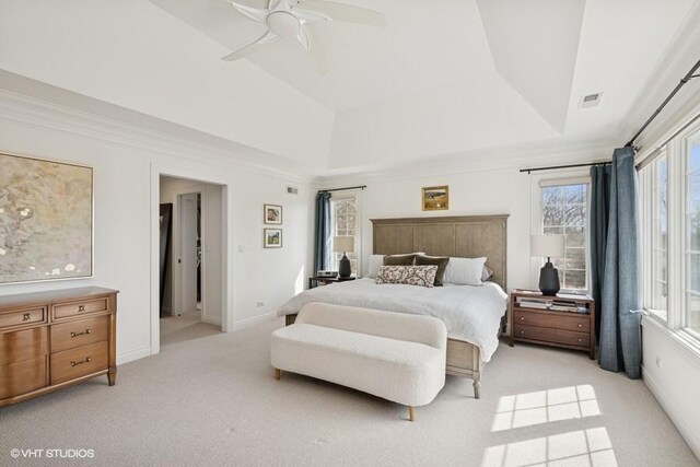 bedroom with visible vents, light carpet, a raised ceiling, baseboards, and ceiling fan