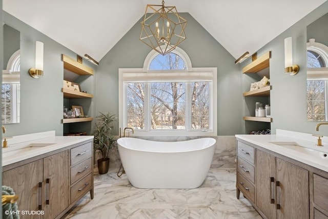 bathroom with a sink, marble finish floor, two vanities, and an inviting chandelier