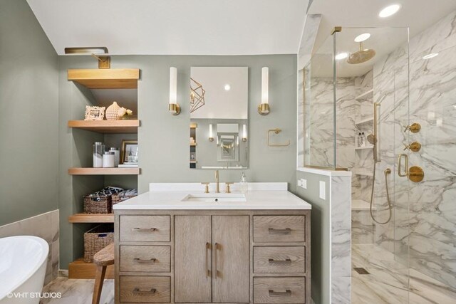 full bathroom with a marble finish shower, a bathtub, and vanity