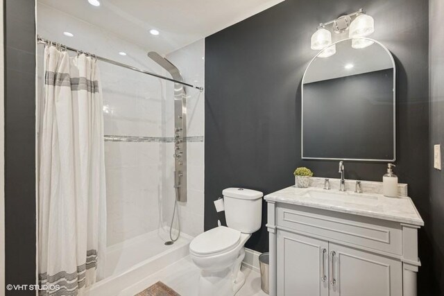 bathroom featuring toilet, vanity, and a tile shower