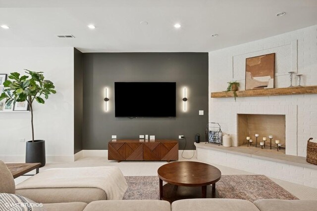 living room featuring recessed lighting, visible vents, baseboards, and a brick fireplace