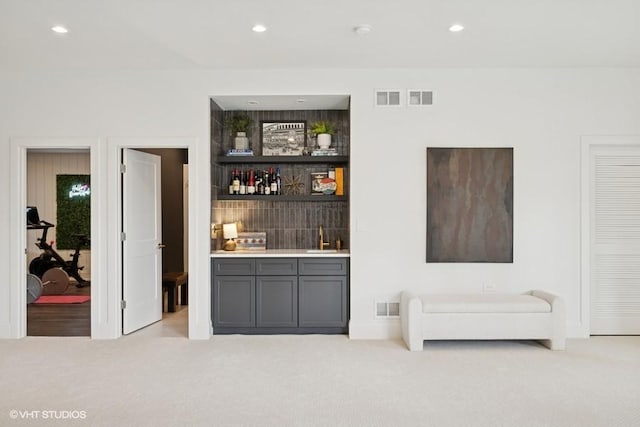 bar with carpet flooring, recessed lighting, wet bar, and a sink