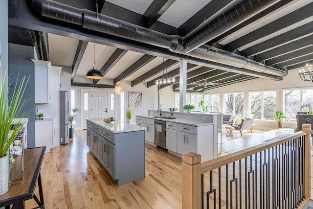 kitchen with an inviting chandelier, gray cabinetry, light countertops, light wood-type flooring, and a center island