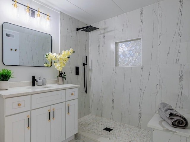 bathroom with vanity and a marble finish shower