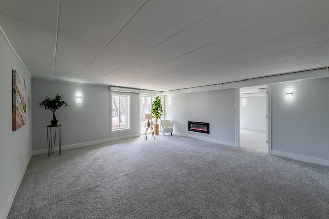 unfurnished living room with a glass covered fireplace, carpet flooring, and baseboards