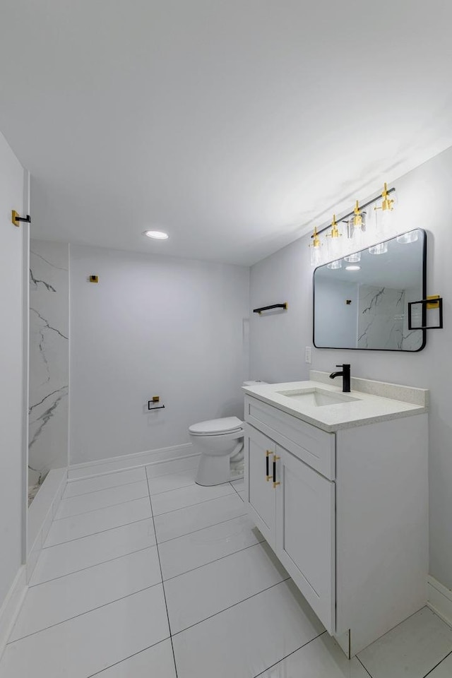 bathroom with a marble finish shower, toilet, vanity, and baseboards