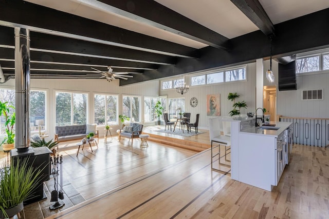 living room with visible vents, beam ceiling, a ceiling fan, and light wood finished floors