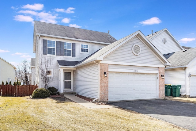 view of front facade with a front lawn, aphalt driveway, fence, an attached garage, and brick siding