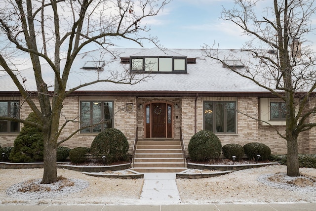 view of front of home with brick siding and a shingled roof