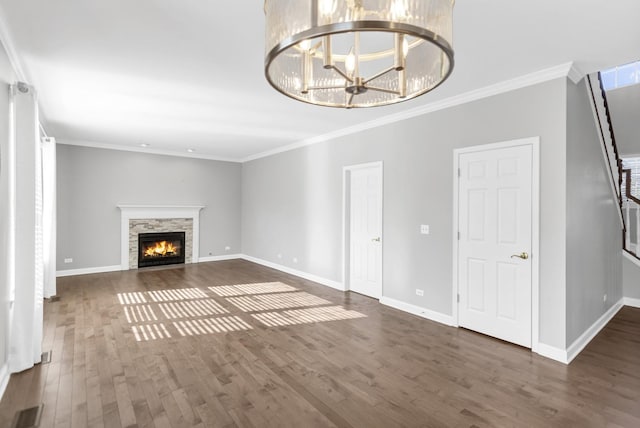 unfurnished living room featuring visible vents, baseboards, wood finished floors, and ornamental molding