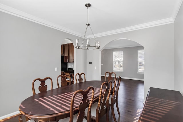 dining room with wood finished floors, baseboards, an inviting chandelier, arched walkways, and crown molding