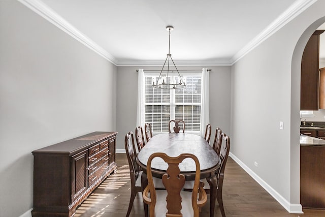 dining room featuring arched walkways, dark wood finished floors, crown molding, and baseboards