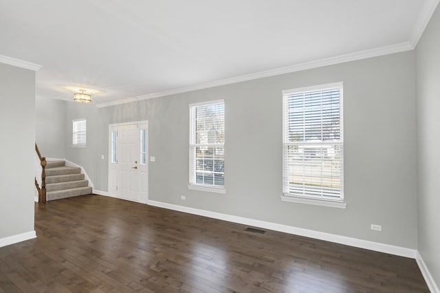 foyer entrance with visible vents, baseboards, dark wood finished floors, stairway, and ornamental molding